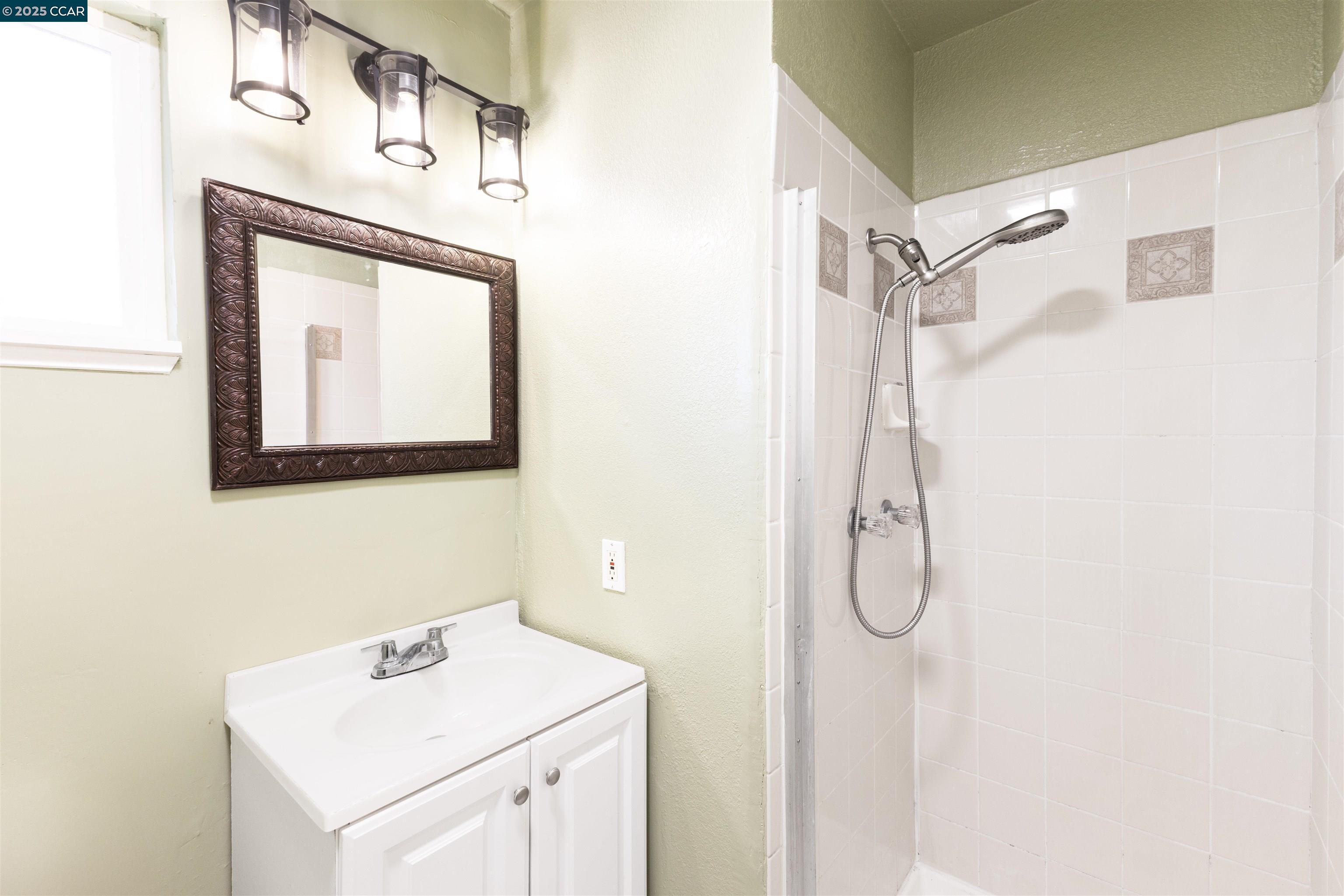 2106 Goff Avenue Pittsburg, CA 94565 - Photo 25 of 27 a bathroom with a sink mirror and a shower