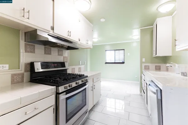 a kitchen with stainless steel appliances a sink a stove and a refrigerator