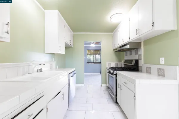 a kitchen with a sink a stove and cabinets