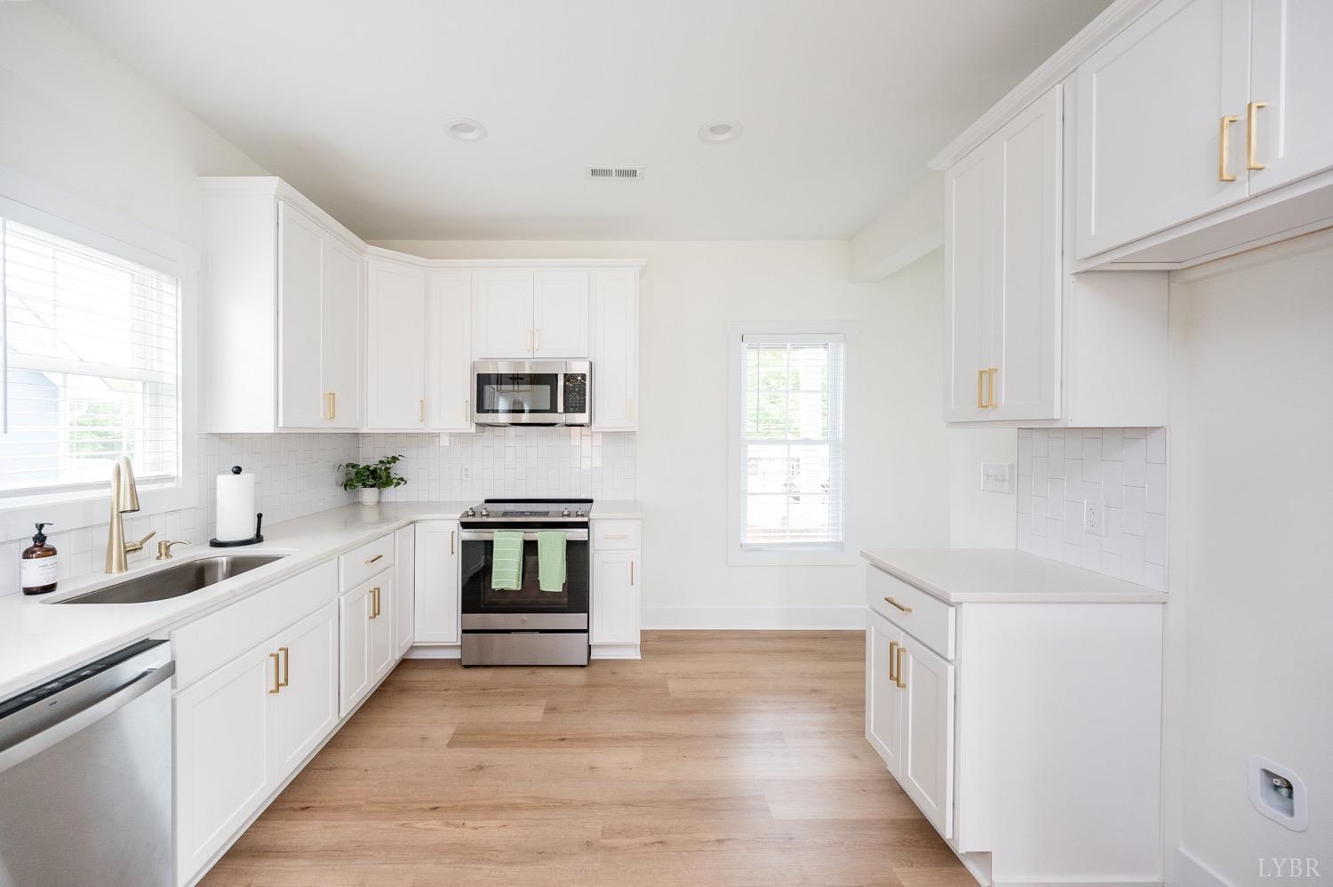 574 Leesville Road Lynchburg, VA 24502 - Photo 21 of 54 a kitchen with granite countertop white cabinets and white appliances