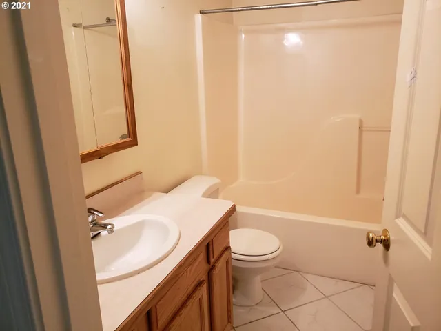 a bathroom with a sink a toilet a mirror and shower