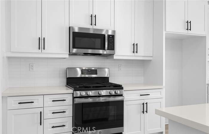 24119 Ashton Corona, CA 92883 - Photo 14 of 45 a kitchen with white cabinets and stainless steel appliances