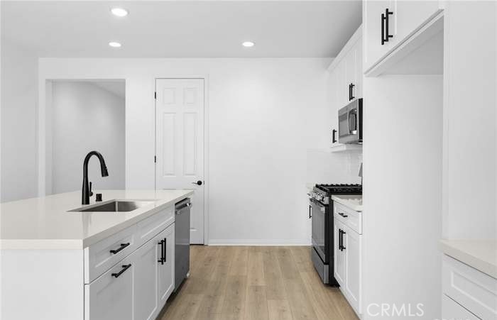 24119 Ashton Corona, CA 92883 - Photo 15 of 45 a kitchen that has a sink a stove and a refrigerator