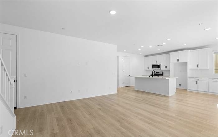 24119 Ashton Corona, CA 92883 - Photo 21 of 45 a view of a kitchen with kitchen island white cabinets and wooden floor