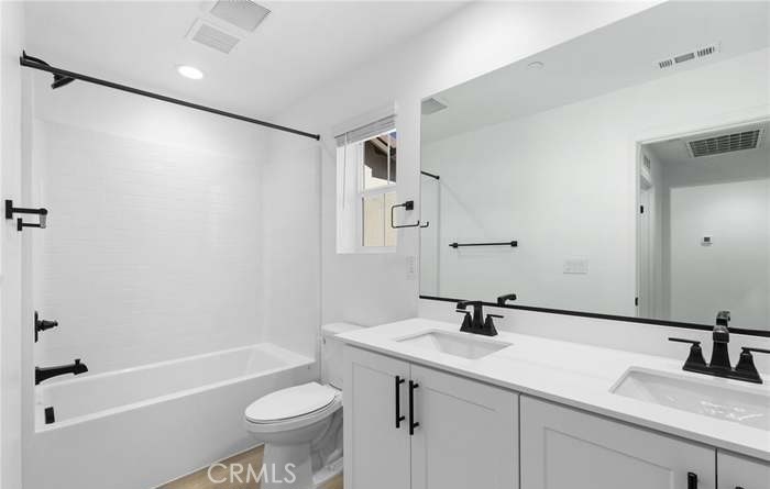 24119 Ashton Corona, CA 92883 - Photo 41 of 45 a bathroom with a granite countertop sink a toilet and a bathtub