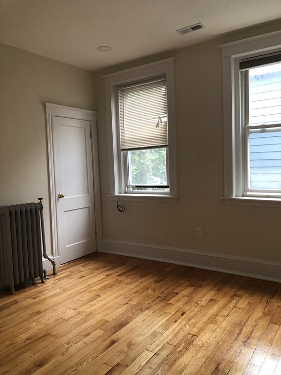 16 Copenger Street, Unit 2 Boston, MA 02120 - Photo 2 of 11 a view of an empty room with wooden floor and a window