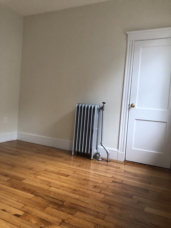 16 Copenger Street, Unit 2 Boston, MA 02120 - Photo 3 of 11 a view of an empty room with wooden floor and a window