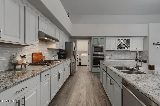 a spacious bedroom with a bed a couch and a dresser next to a window