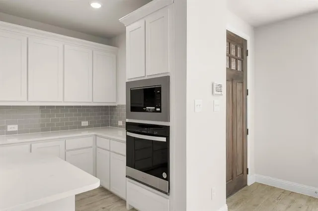 a kitchen with granite countertop a sink a stove and cabinets