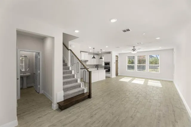 a kitchen with a stove a sink a center island and cabinets