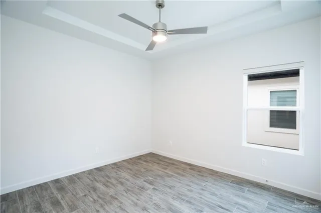an empty room with a window and a ceiling fan