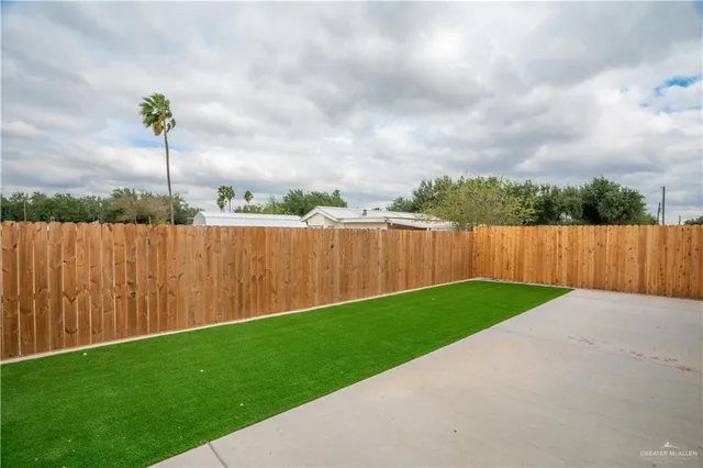 a view of a backyard with wooden fence