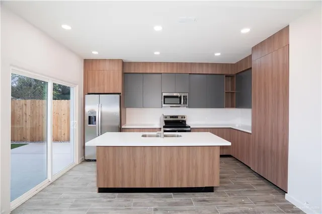 a kitchen with kitchen island a counter top a stove and a refrigerator