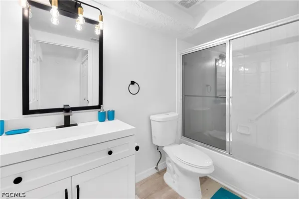 a bathroom with a sink a toilet a mirror and shower