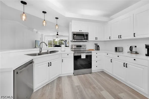 a kitchen with cabinets stainless steel appliances and sink