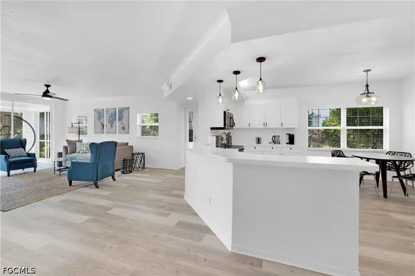 a living room with furniture a dining table and chairs with wooden floor