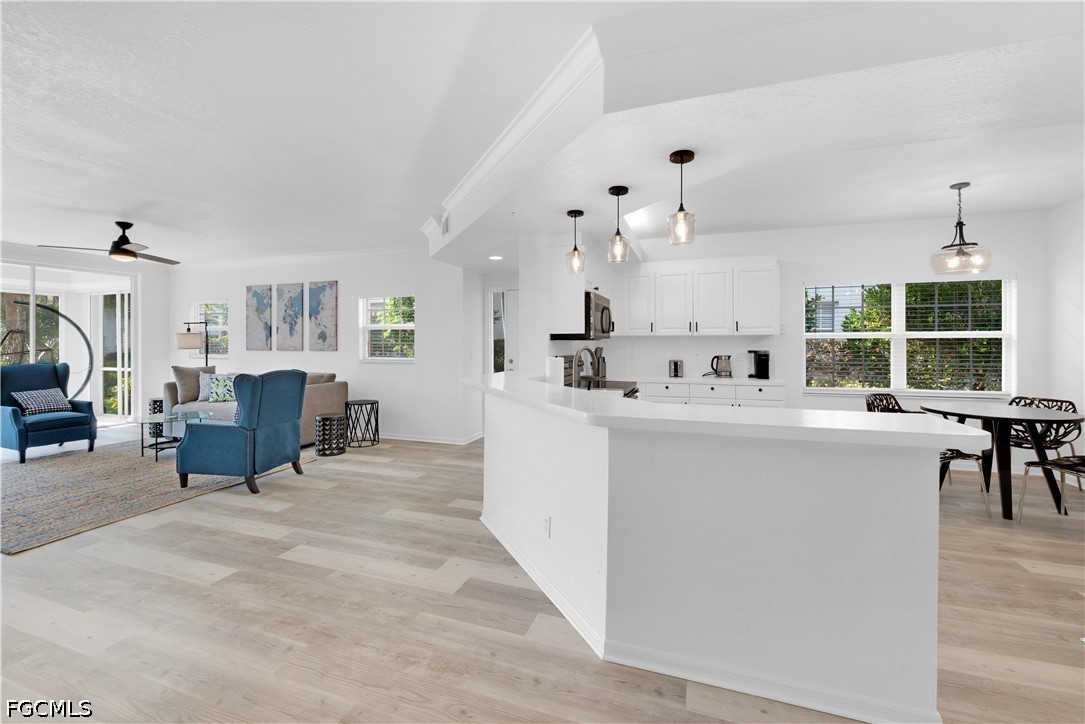 6800 Satinleaf Road South, Unit 104 Naples, FL 34109 - Photo 4 of 12 a living room with furniture a dining table and chairs with wooden floor