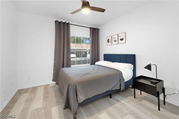 a bedroom with a bed a window and a chandelier