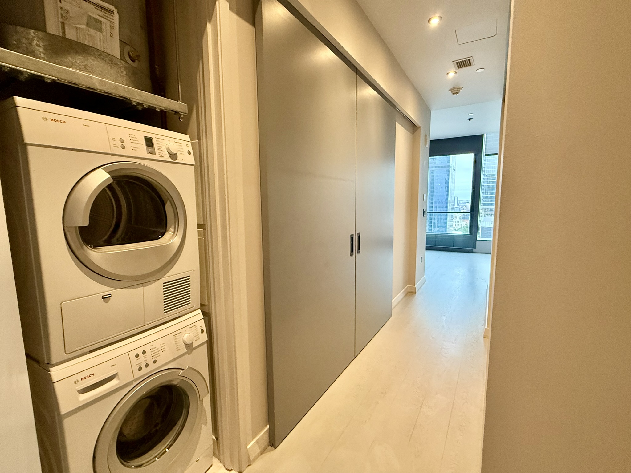 210 Lavaca Street, Unit 2809 Austin, TX 78701 - Photo 15 of 17 Integrated laundry facilities streamline daily routines in this well-appointed hallway.