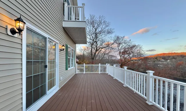a view of a balcony with wooden floor and fence