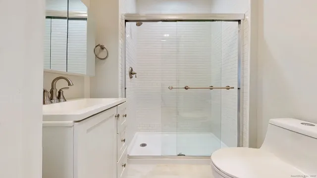 a bathroom with a shower a toilet and a sink