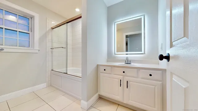 a bathroom with a sink a mirror and shower