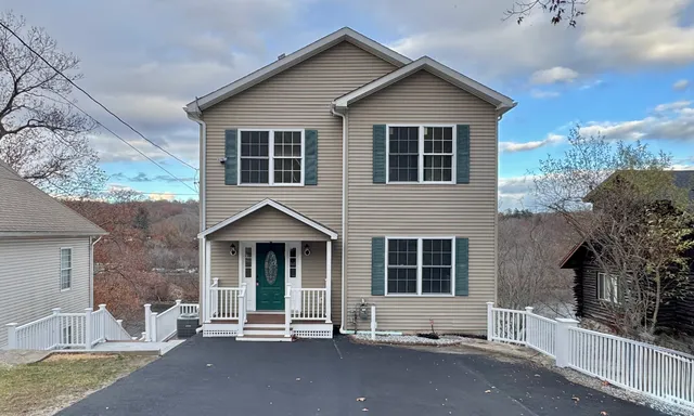 a view of a house with backyard and sitting area