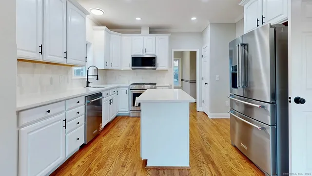 a kitchen with stainless steel appliances a refrigerator sink and cabinets