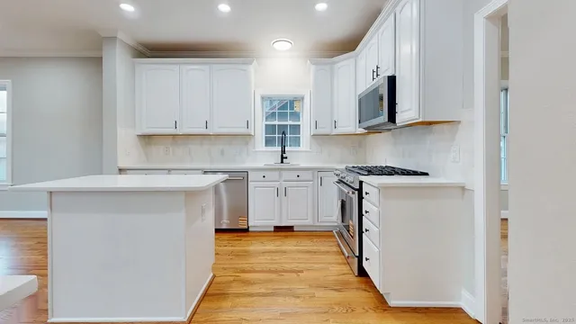 a kitchen with stainless steel appliances granite countertop a stove a sink and a microwave