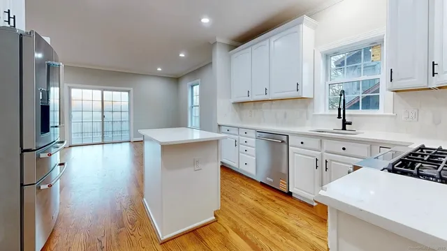 a kitchen with stainless steel appliances a white stove top oven sink and cabinets