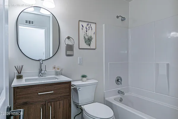 an aerial view of a city with lots of residential buildings and ocean view in back