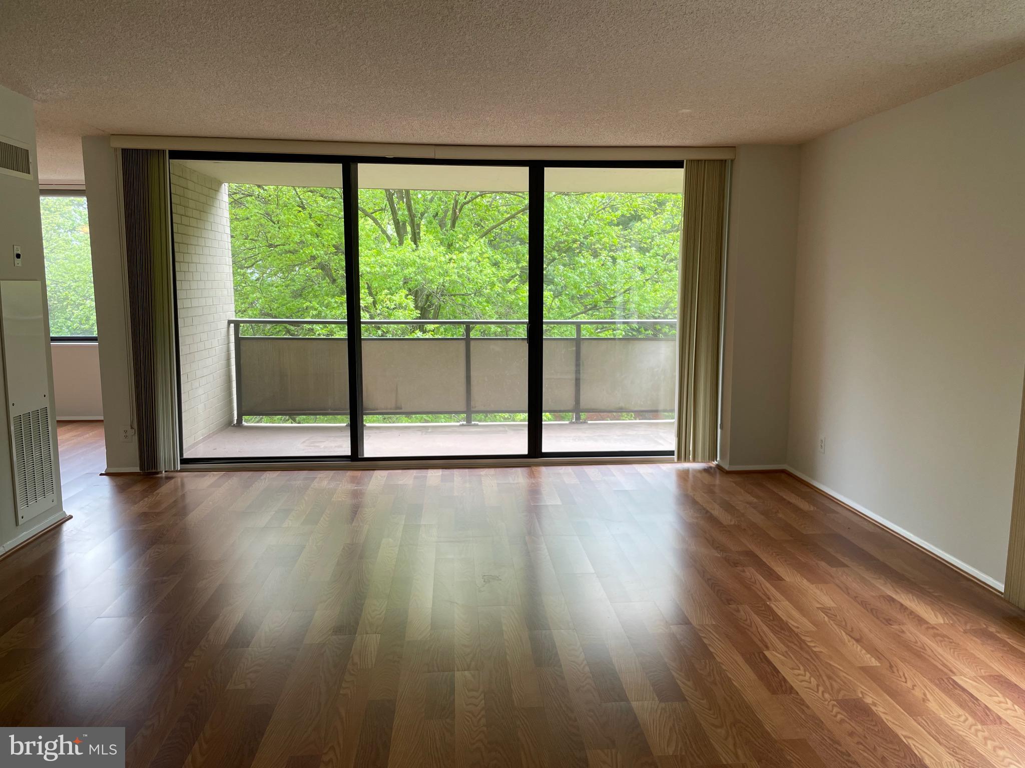 5225 Pooks Hill Road, Unit 228S Bethesda, MD 20814 - Photo 4 of 28 a view of an empty room with wooden floor and a window
