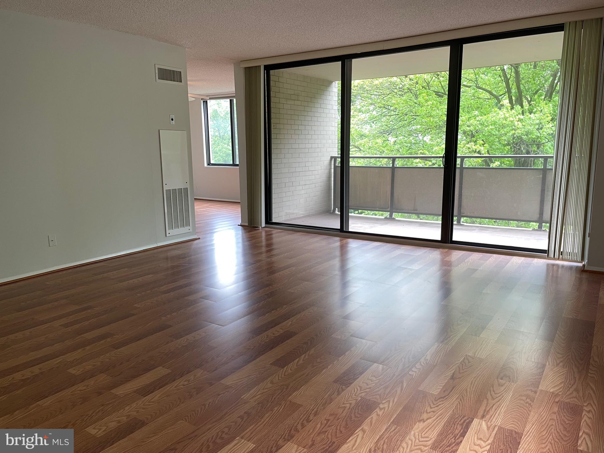 5225 Pooks Hill Road, Unit 228S Bethesda, MD 20814 - Photo 5 of 28 a view of an empty room with wooden floor and a window