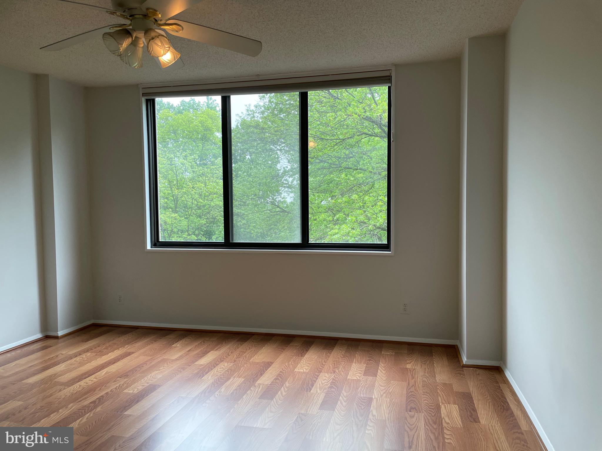 5225 Pooks Hill Road, Unit 228S Bethesda, MD 20814 - Photo 6 of 28 a view of an empty room with wooden floor and a window
