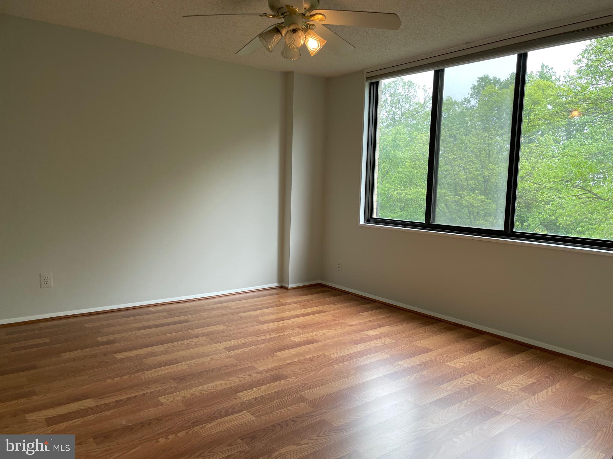 5225 Pooks Hill Road, Unit 228S Bethesda, MD 20814 - Photo 7 of 28 a view of an empty room with wooden floor and a window