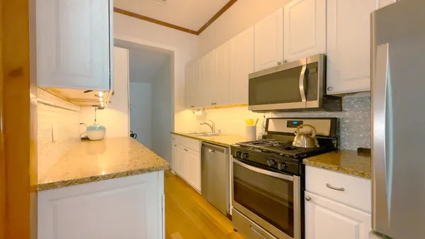 a kitchen with stainless steel appliances granite countertop a sink stove and refrigerator