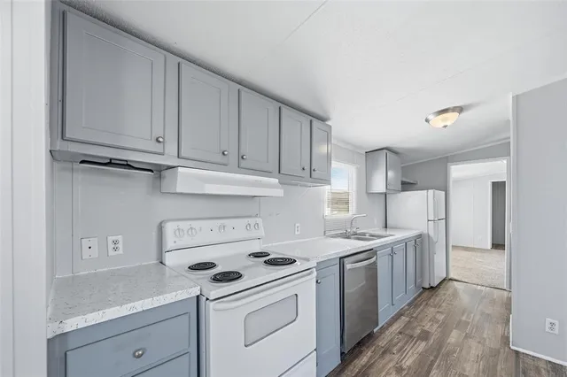 a kitchen with a white stove top oven and white cabinets