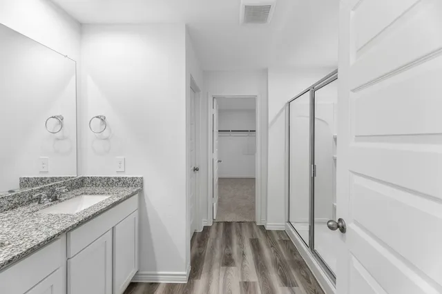 a bathroom with a granite countertop sink a toilet and shower