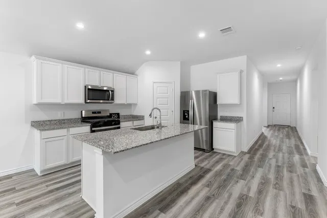 a kitchen with stainless steel appliances a refrigerator sink and microwave