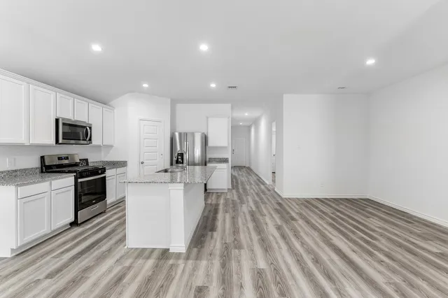 a large kitchen with a sink and stainless steel appliances