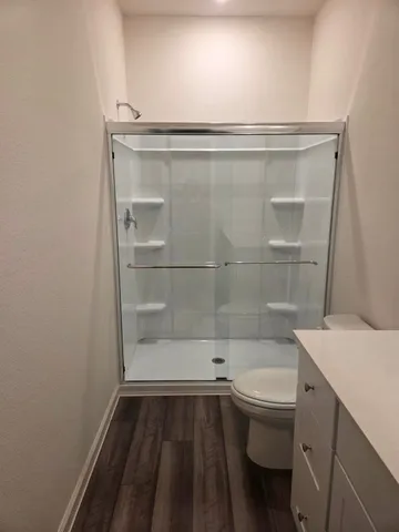 a bathroom with a sink a toilet and shower