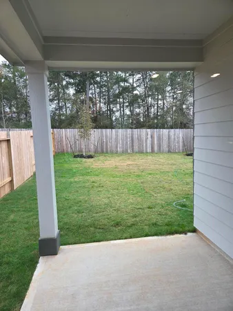 a view of a yard with a small pool and wooden fence