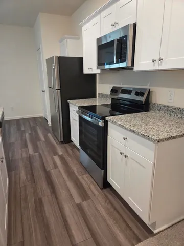 a kitchen with stainless steel appliances granite countertop a refrigerator stove and microwave