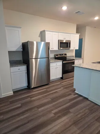 a kitchen with stainless steel appliances a refrigerator stove and microwave