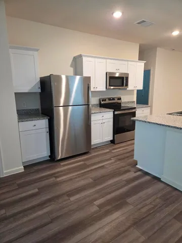 a kitchen with stainless steel appliances a refrigerator stove and microwave