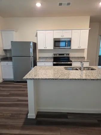 a kitchen with appliances a sink and a refrigerator