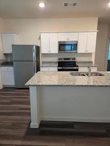 a kitchen with appliances a sink and a refrigerator