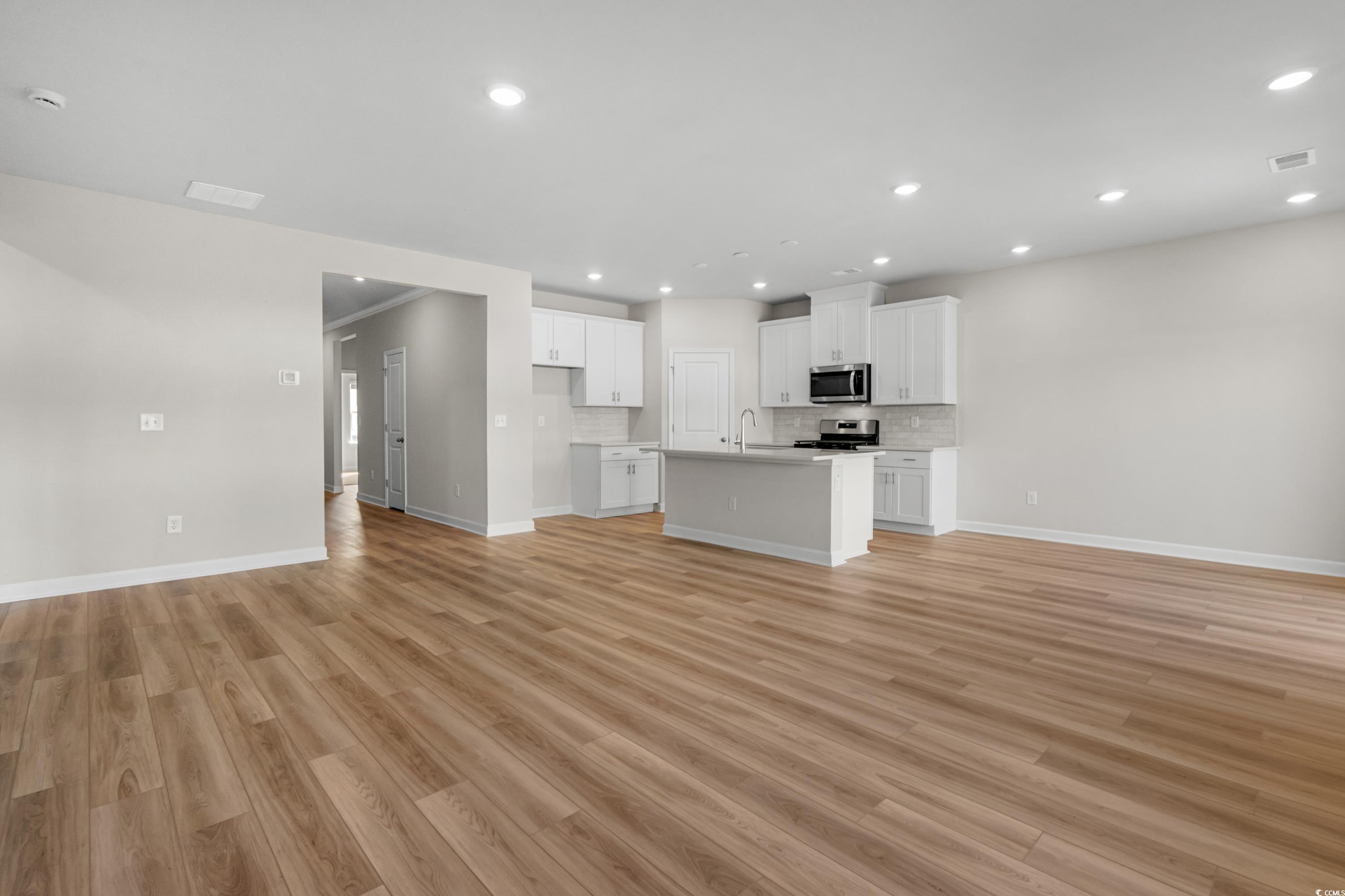 1044 Lauryn Oak Loop Longs, SC 29568 - Photo 28 of 28 Kitchen featuring white cabinetry, open floor plan, light wood-type flooring, recessed lighting, and an island with sink*options and colors may vary