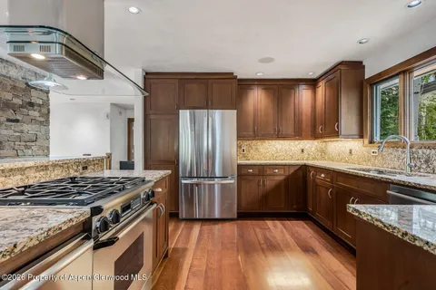 a kitchen with granite countertop a stove and a refrigerator