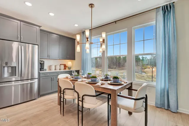 a kitchen with a table chairs refrigerator and microwave